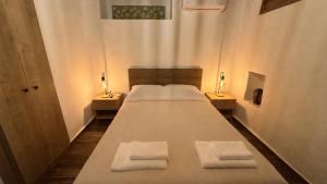 a large bed in a room with two night stands at Meliti Home in Therma
