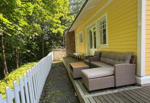 a porch with wicker furniture on a yellow house at Villa Tourula in Jyväskylä