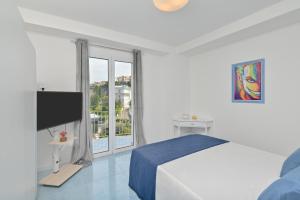 a white bedroom with a bed and a large window at Agropoli Palace in Agropoli +21 photos