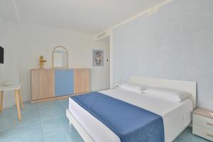 a white bedroom with a bed and a table at Agropoli Palace in Agropoli