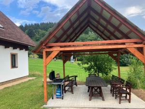 a wooden pavilion with picnic tables and a grill at Chalupa a apartmány Lojka in Benecko