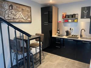 a kitchen with a sink and a counter with a table at Love Room SPA l'impertinente in Isbergues