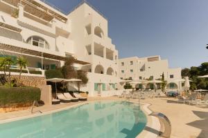 a hotel with a swimming pool in front of a building at Hotel Cala Dor - Adults Only in Cala d´Or
