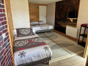 a room with two beds and a television in it at Les Roses Des Bois in Murat-le-Quaire
