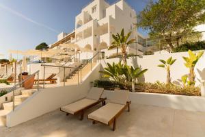 a view of a building with two chairs and stairs at Hotel Cala Dor - Adults Only in Cala d´Or