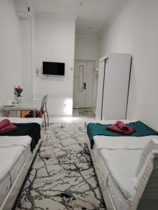 a room with two beds and a table and a tv at Chevrolet Hotel in Namangan +36 photos
