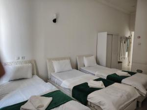 a room with three beds with towels on them at Chevrolet Hotel in Namangan