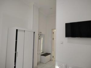 a white room with a flat screen tv on a wall at Chevrolet Hotel in Namangan