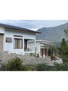 a white house with mountains in the background at Slash Villa in Silimapuluh