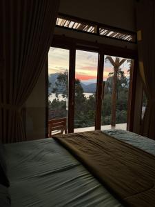 a bedroom with a bed in front of a window at Slash Villa in Silimapuluh