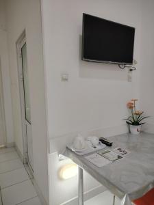 a room with a table with a tv on a wall at Chevrolet Hotel in Namangan