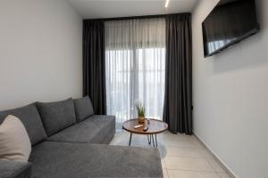 a living room with a couch and a table at White Pampas Tiny Houses 1 in Paralia Dionysiou