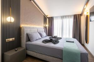 a bedroom with a bed with a black bow on it at White Pampas Tiny Houses 1 in Paralia Dionysiou +26 photos