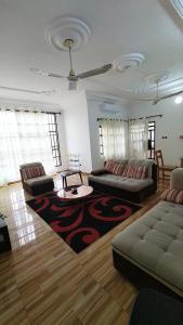 a living room with two couches and a rug at Home Appart in Porto-Novo