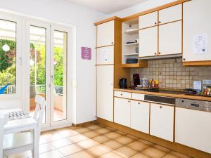 a kitchen with white cabinets and a table at rooms lux city in Luxembourg