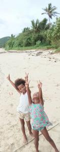 two children are playing on the beach at Nanz's Homestay in Ngunu