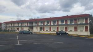 a large building with cars parked in a parking lot at Flagship Inn in Petersburg