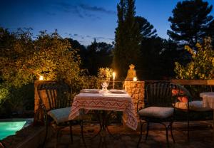 a table and chairs with a table and a statue at Les Rosées in Mougins
