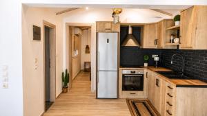 a kitchen with a refrigerator and wooden cabinets at Navis Luxury in Skala Kallirachis +20 photos