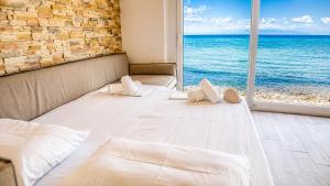 a bedroom with a large bed with a view of the ocean at Navis Luxury in Skala Kallirachis