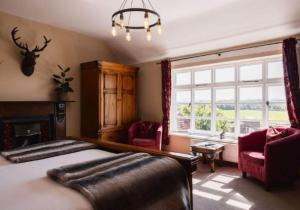 a bedroom with a bed and a fireplace and a window at The Haughmond in Upton Magna