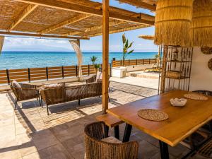a dining room with a table and the ocean at Navis Luxury in Skala Kallirachis