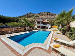 a swimming pool in front of a house at Villa Lemonia in Malia