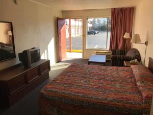 a hotel room with a bed and a tv at Flagship Inn in Petersburg