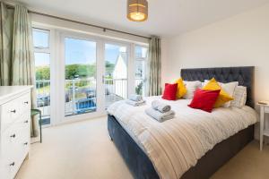 a bedroom with a large bed and a large window at 6 Bluestone Point in Mortehoe