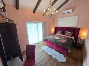 a bedroom with a purple bed and a chandelier at Landhaus Sweet Escape in Löningen