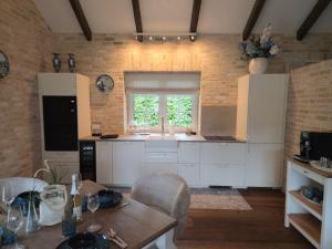 a kitchen with white cabinets and a table and a window at Landhaus Sweet Escape in Löningen