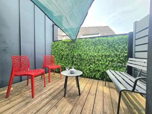 two red chairs and a table on a balcony at Indus, Confort en centre-ville in Vannes
