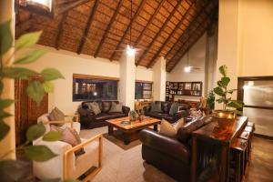 a living room with leather couches and a table at Senalala Safari Lodge in Klaserie Private Nature Reserve