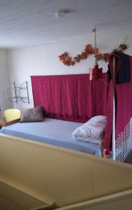 a bed in a room with a red curtain at Sundqvistens basement in Emkarby