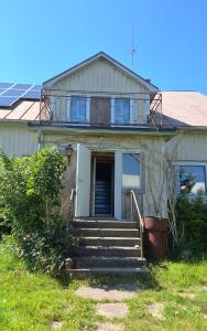 a house with stairs and a balcony on top of it at Sundqvistens basement in Emkarby