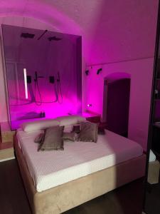 a bedroom with a bed with pink lighting at Lupariello Relais in Altamura +2 photos