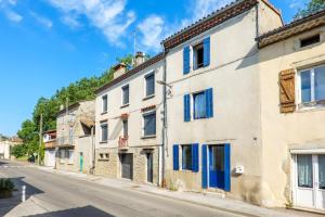 a street in an old town with blue shutters at Maison de Charme - Écrin de Nature in Saint-Privat