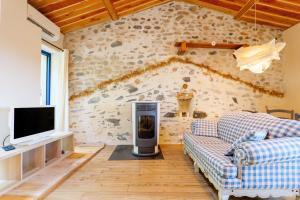 a living room with a couch and a tv at Maison de Charme - Écrin de Nature in Saint-Privat