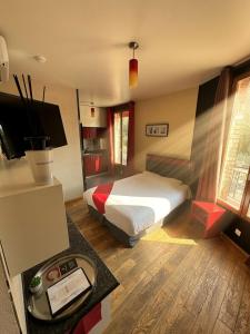 ein Schlafzimmer mit einem Bett und einem Schreibtisch mit Fernseher in der Unterkunft Marinha Hôtel in Gentilly
