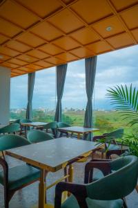 a room with tables and chairs and a large window at Hotel 5 Elements By Fidato Hotels in Akalkot