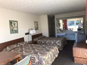 a hotel room with two beds and a desk at Flagship Inn in Petersburg