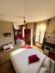 ein großes weißes Bett mit einem roten Kissen in einem Zimmer in der Unterkunft Marinha Hôtel in Gentilly