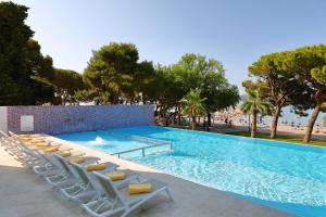 a large swimming pool with lounge chairs and a beach at Ilirija Resort Hotel Ilirija in Biograd na Moru