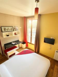 ein Schlafzimmer mit einem weißen Bett und einem Fenster in der Unterkunft Marinha Hôtel in Gentilly