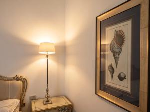 a bedroom with a picture and a lamp and a bed at La Locanda Del Carrubo in Mattinata