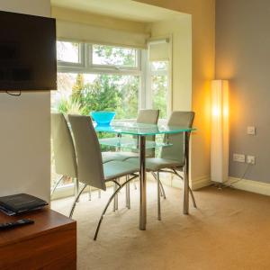 a dining room with a table with chairs and a window at Bagshaw Lodge in Bakewell