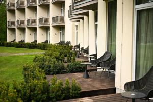 ein Balkon eines Gebäudes mit Stühlen und einem Tisch in der Unterkunft SPA VILNIUS Druskininkai in Druskininkai