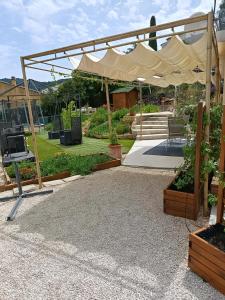 a patio with a tent and some plants at T2 Les Roses in Le Beausset