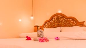 a bedroom with a white bed with a wooden headboard at Kendwa Stay in Kendwa