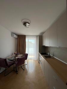 a kitchen with a table and a dining room at Luna Residence in Baia Mare